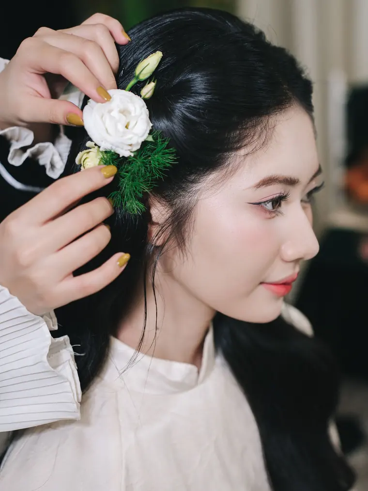生花の髪飾りをつけた、まとめ髪のヘアセット